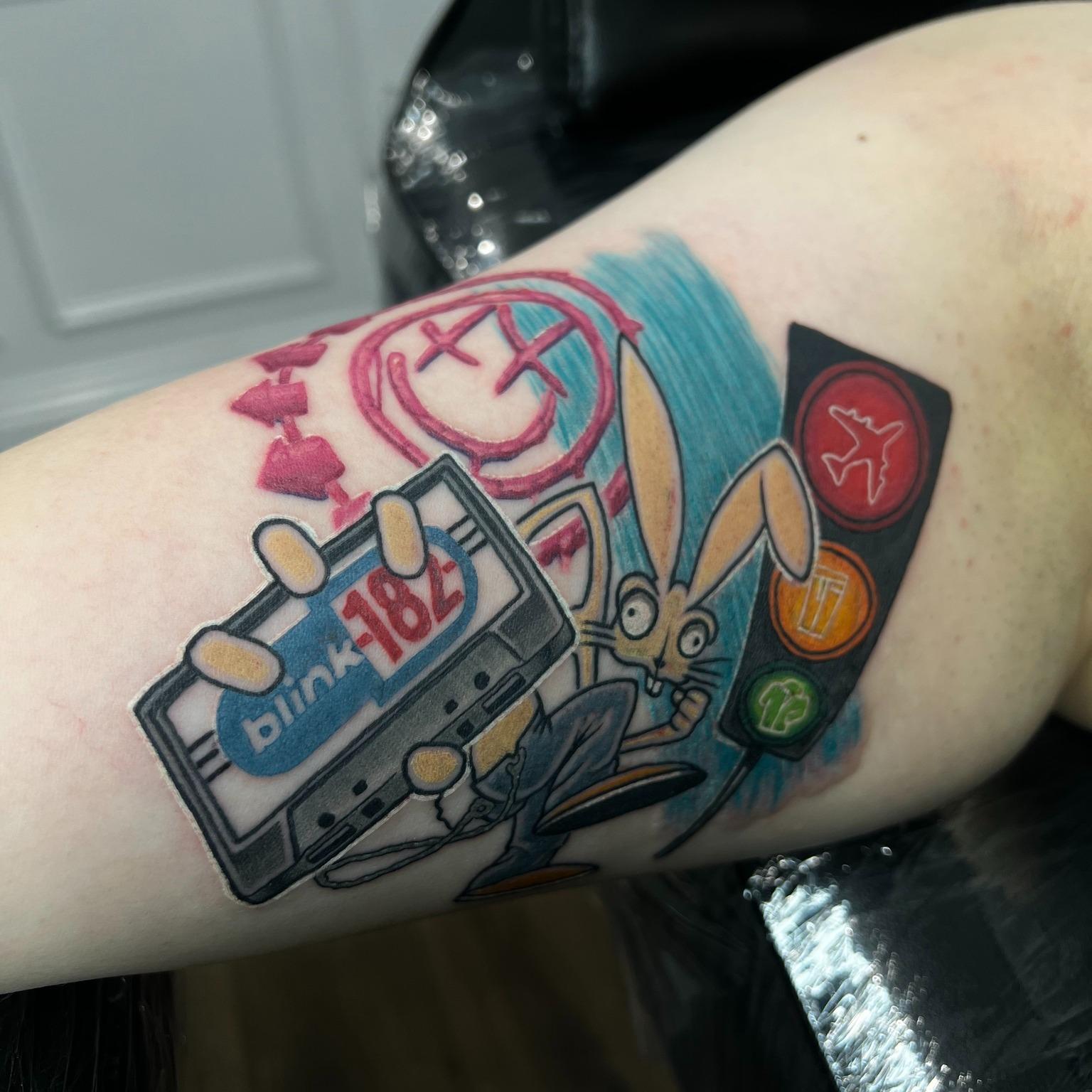 Colour Blink-182 tattoo with the smiley logo, cassette and rabbit by Independence Ink.