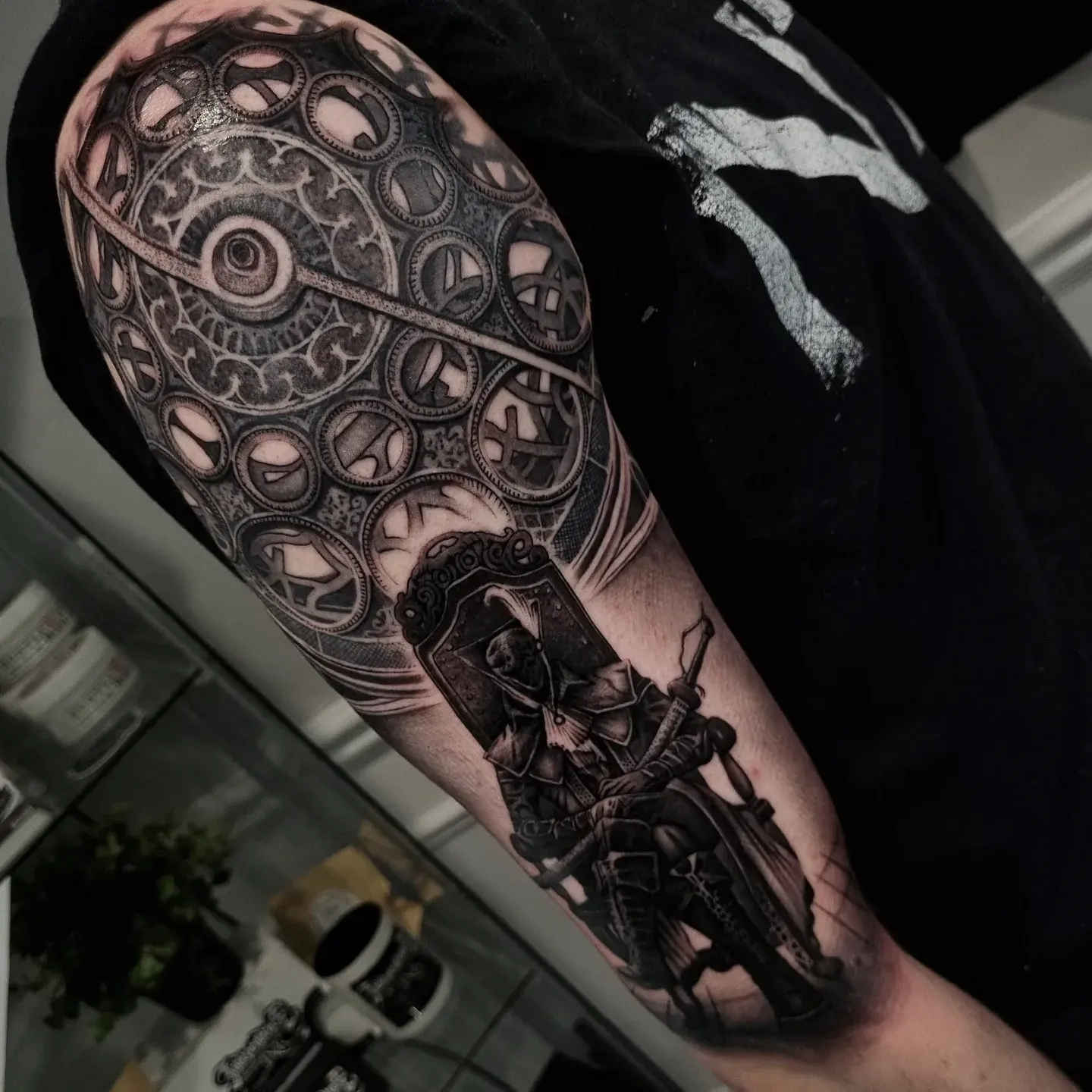 Black and grey Bloodborne hunter gaming tattoo with ornate clockwork background by Independence Ink.