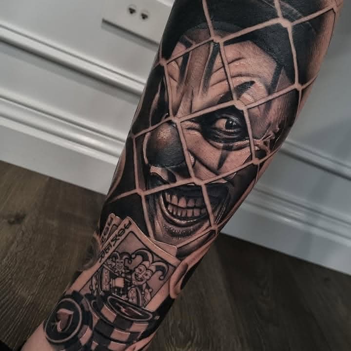 Black and grey casino tattoo with a grinning clown, playing cards and chips by Independence Ink.