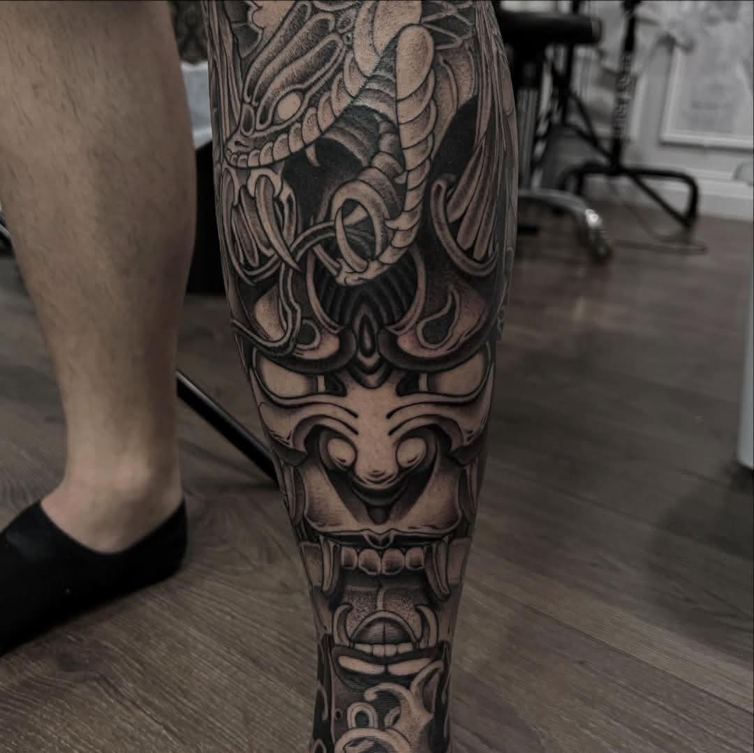 Black and grey Japanese leg tattoo with a dragon and Hannya mask by Independence Ink.