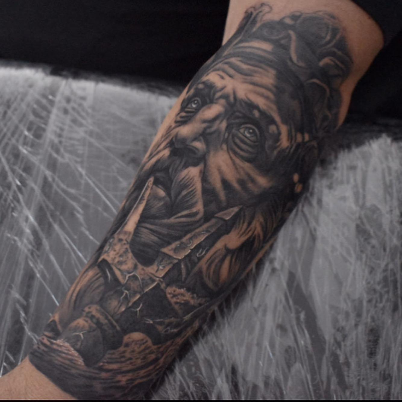 Poseidon forearm tattoo starting a black and grey ocean-themed sleeve by Independence Ink.