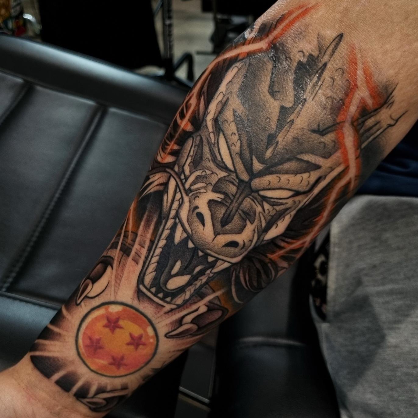 Dragon Ball tattoo of Shenron with a colour four-star dragon ball by Independence Ink.