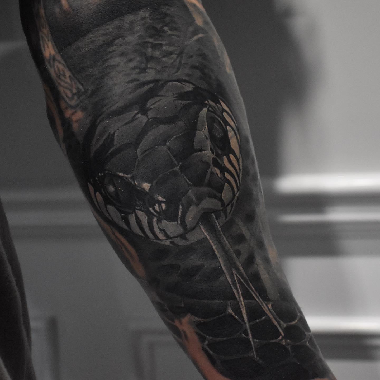 Blackwork snake sleeve cover-up tattoo over an old faded portrait by Independence Ink.