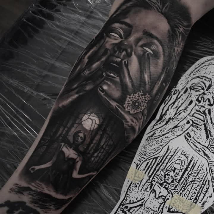 Black and grey surreal portrait tattoo of a crying woman and caged figure by Independence Ink.