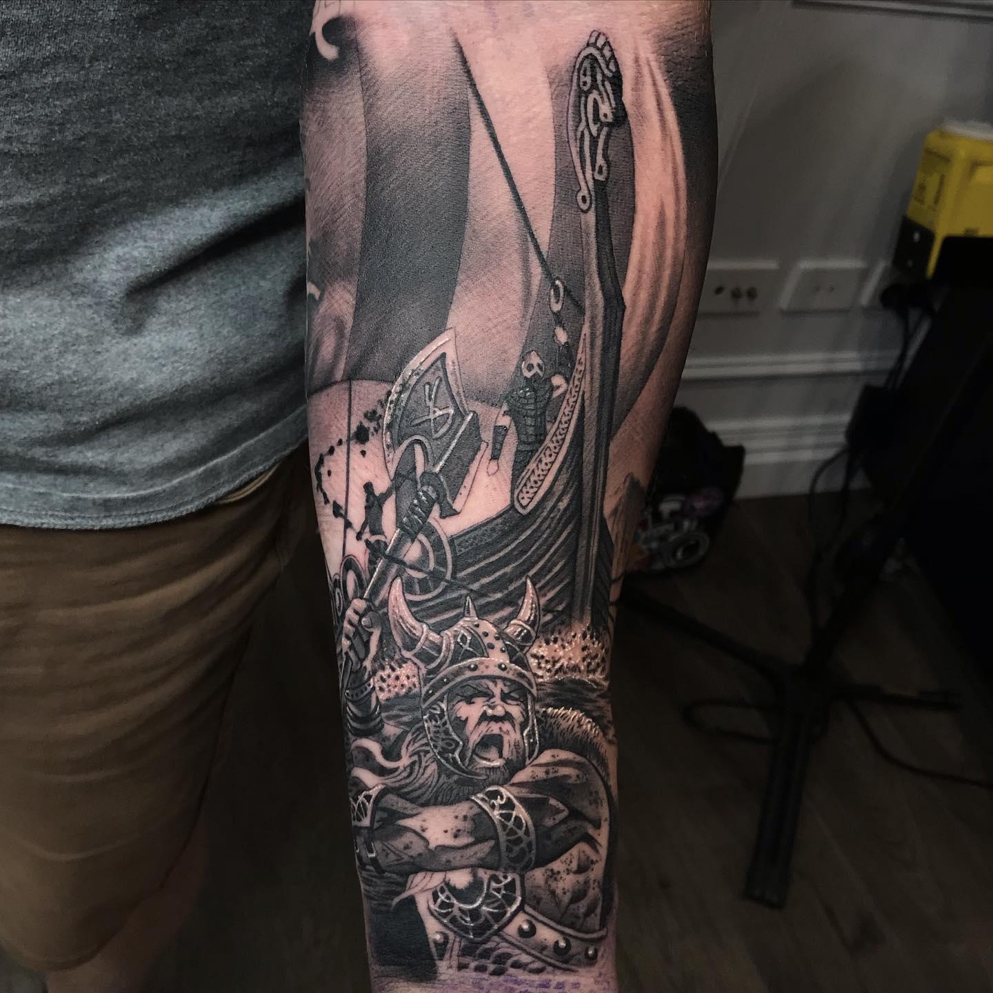 Viking warrior and longship forearm sleeve tattoo in black and grey by Independence Ink.