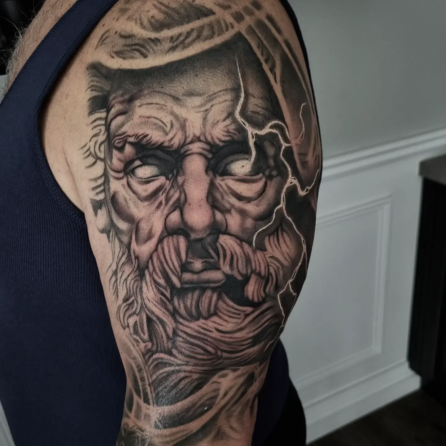 Zeus statue half sleeve tattoo with lightning in black and grey by Independence Ink.