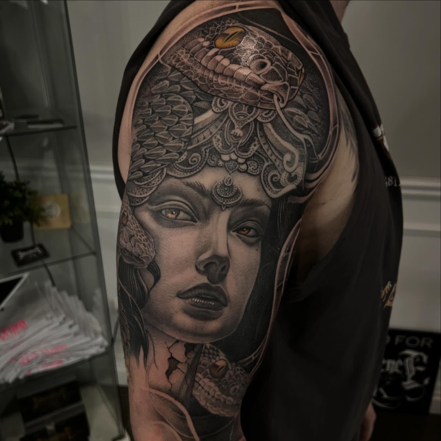 Black and grey Medusa half sleeve tattoo with snakes by Independence Ink in Camden.